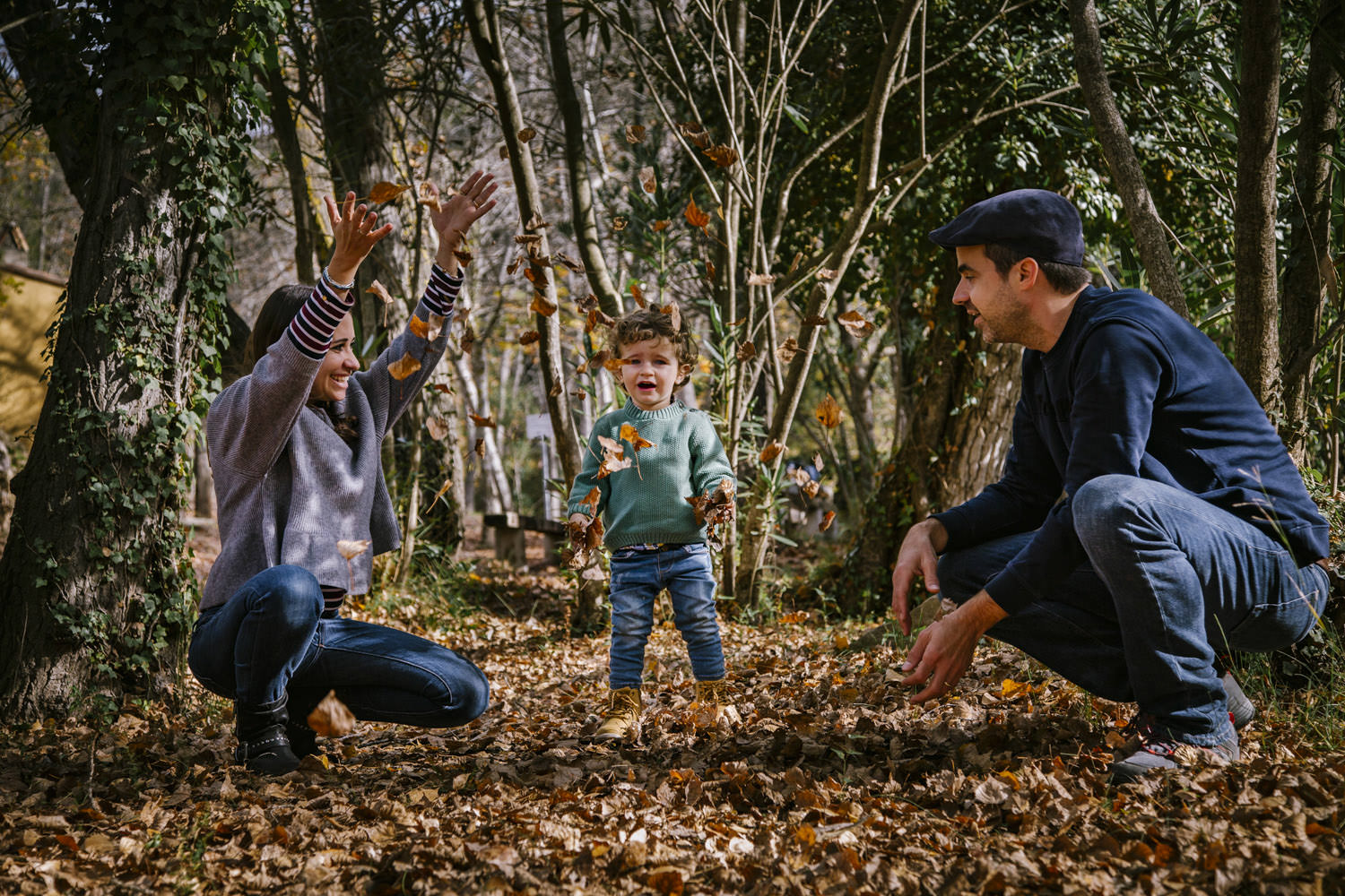 padres jugando con hijo en bosque